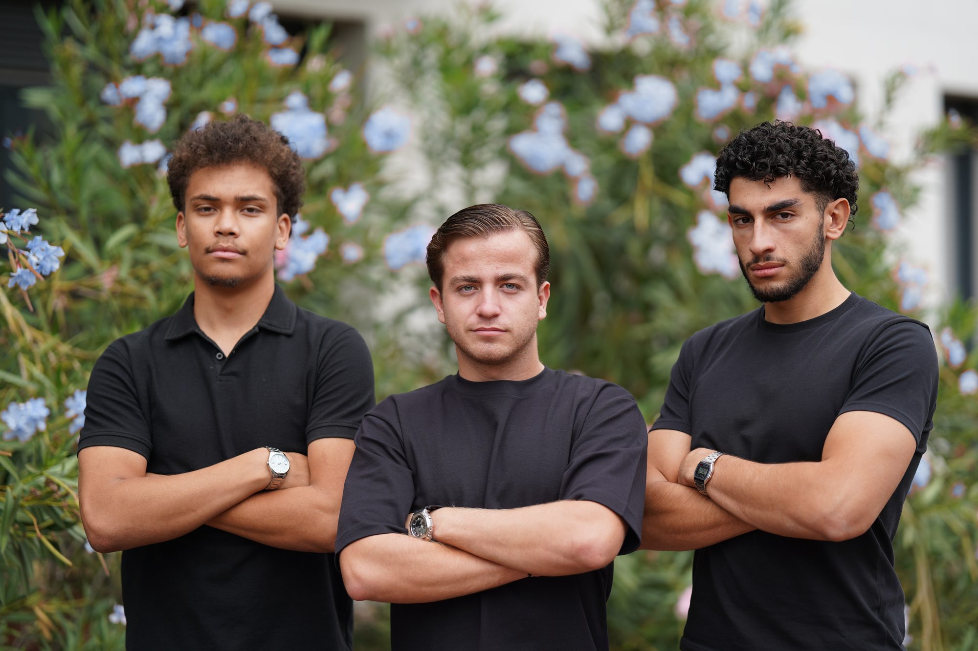 Jules, Amine et Hugo, les trois fondateurs de SQWAD, bras croisés devant des lauriers-roses